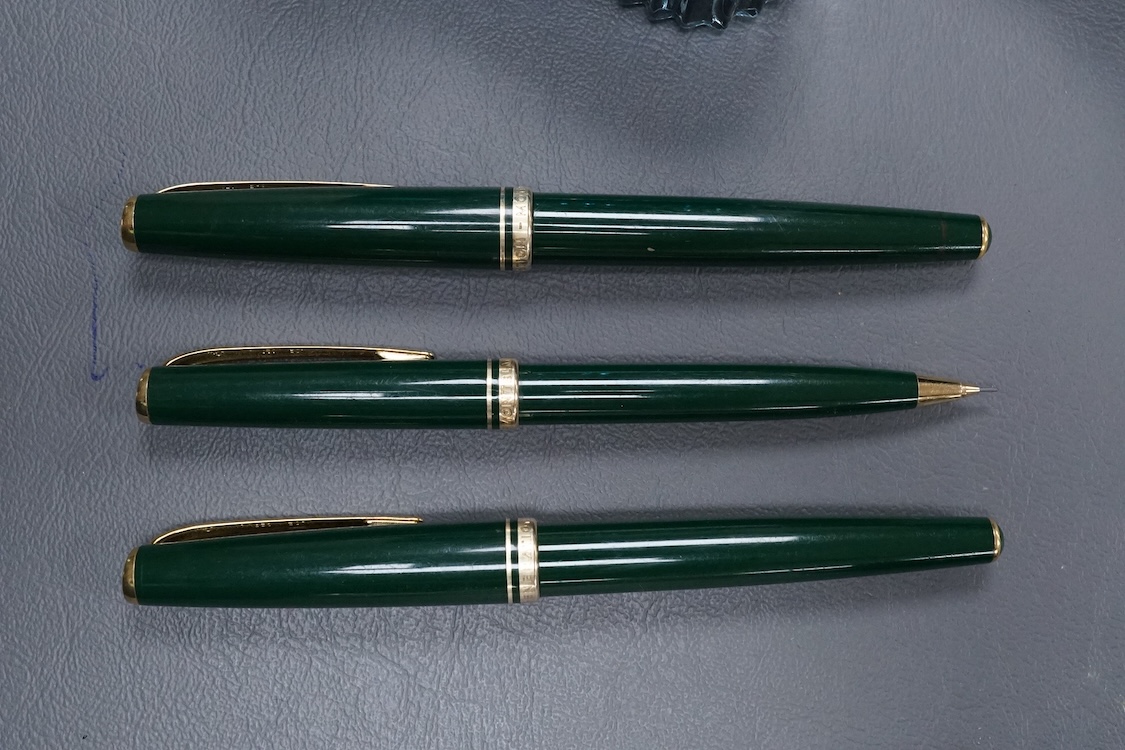 Three Mont Blanc pens in a green leather Mount Blanc case and two inkwells.